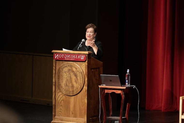 Molly Smith gestures to the audience as she speaks from a podium.